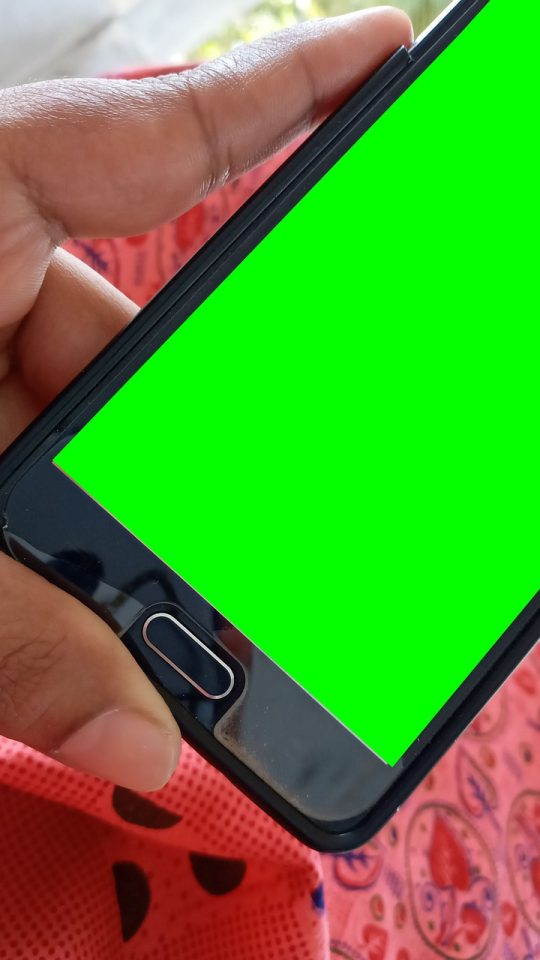 教师在教室后排用手机记录课堂观察笔记，屏幕上显示带标签的笔记编辑界面与保存按钮